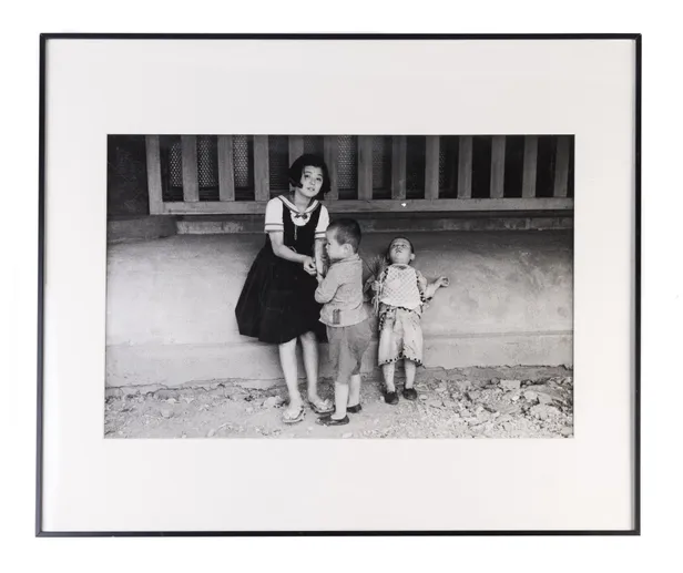 Children standing in front of old house.